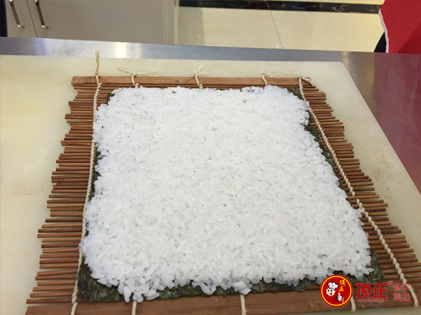 用力压紧平米饭,然后撕去保鲜膜。 用力压紧平米饭,然后撕去保鲜膜。